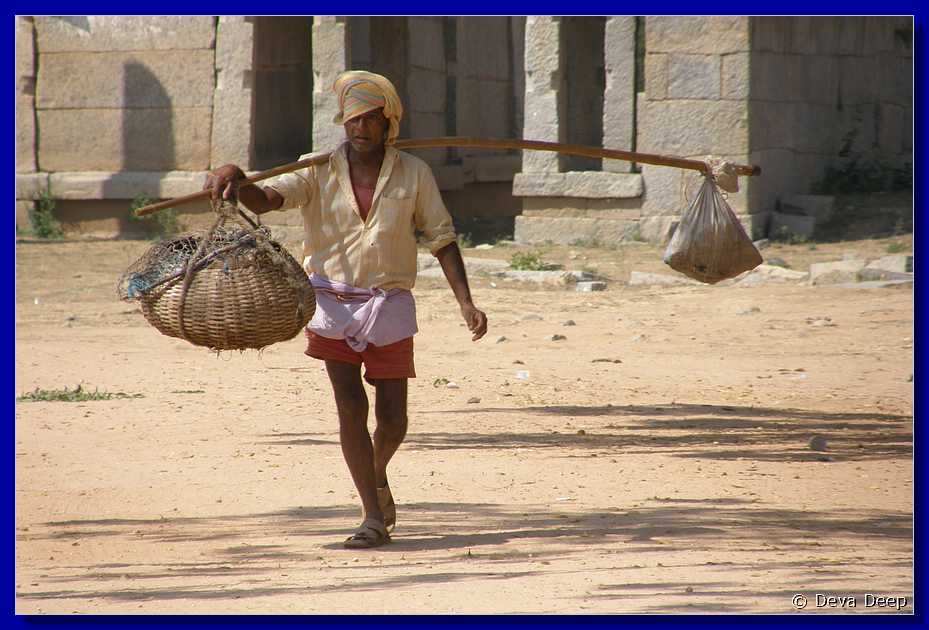 H145 Hampi Vitthala temple man with bags 78